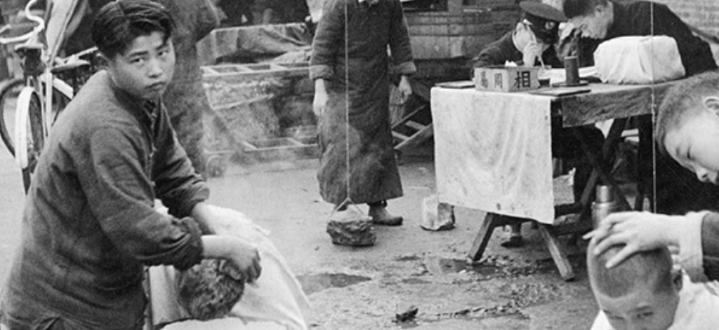 In un tempo di panico e di fughe, shampoo e taglio dei capelli per la strada. Shanghai, fine dicembre 1948 © Fondation Henri Cartier-Bresson Magnum Photos